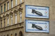 an image of two large billboards depicting a bomb labelled "sanctions" and the text "Brussel's sanctions are destroying us"
