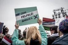 people holding up campaign signs on the opposition rally of 15 March in Budapest