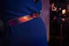 image of a pregnant belly in a blue dress, with a rainbow belt
