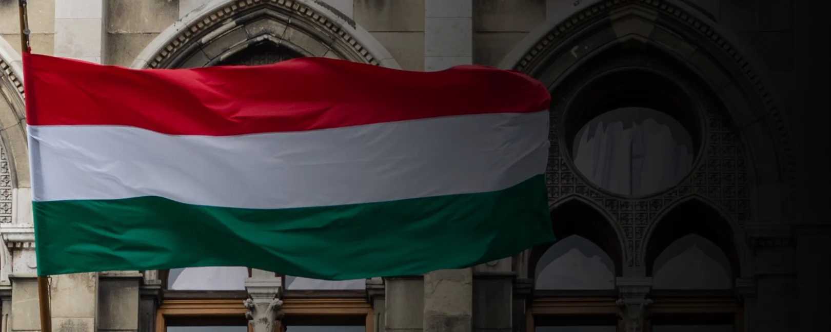 Parliament in Budapest, Hungary, with waving Hungarian flags