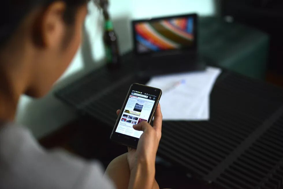 a woman reading an online news site on her smartphone