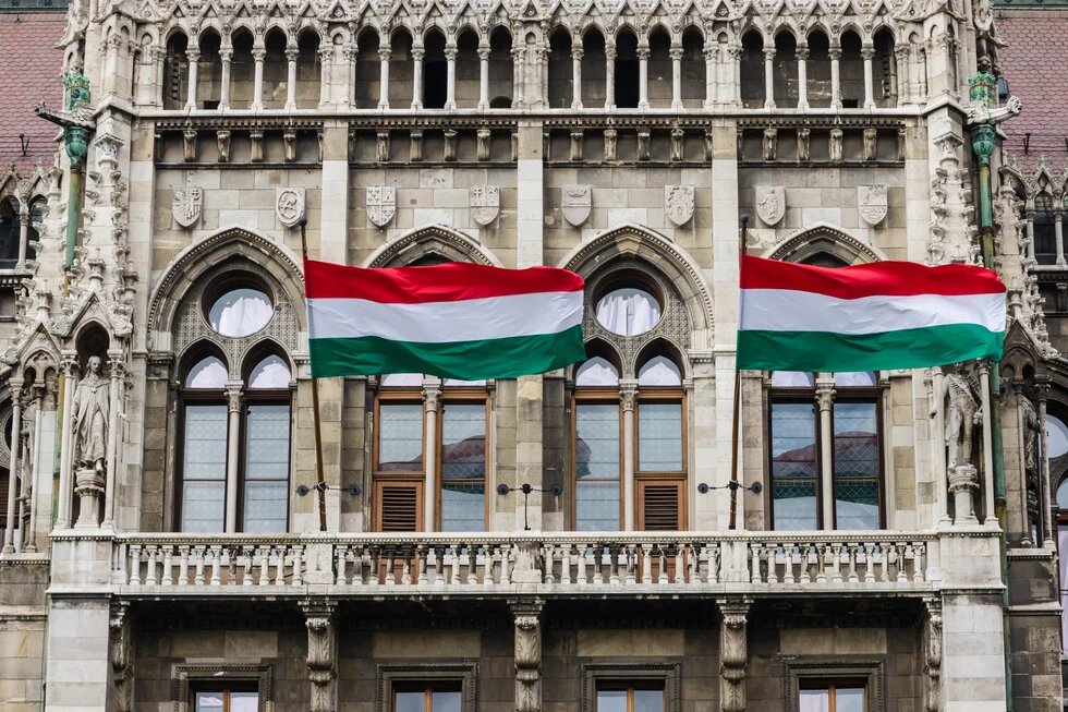 Detail of Parliament in Budapest, Hungary, with waving Hungarian flags