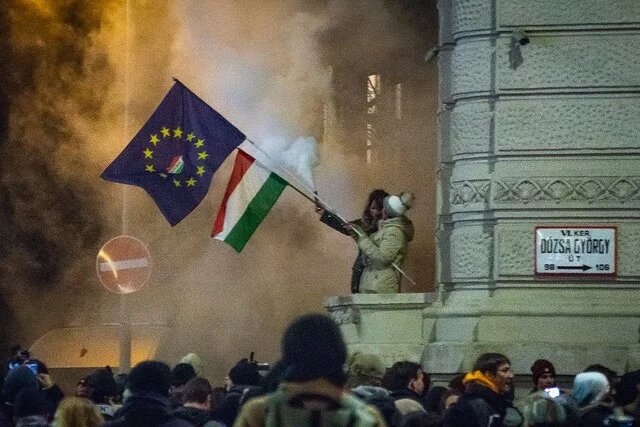 Protesters are waving an EU and a Hungarian flag Protesters are waving an EU and a Hungarian flag